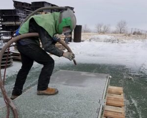 worker soda blasting aluminum hatches
